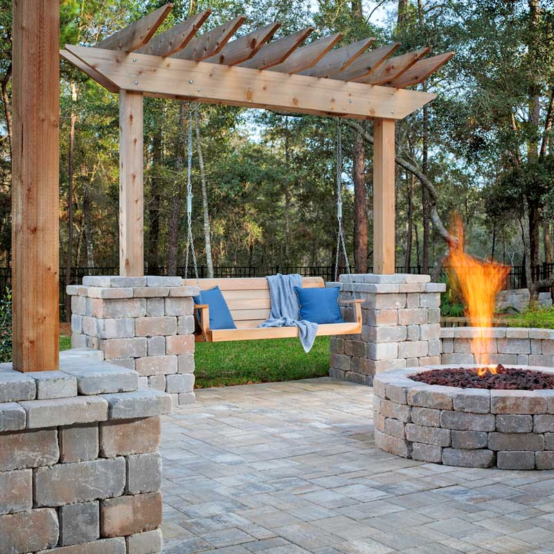custom backyard patio with swing pergola gas fireplace stone pavers