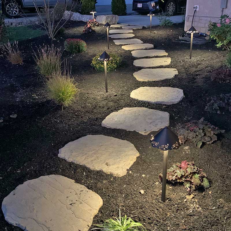 stone paver walkway in mulch with ground lighting in residential home